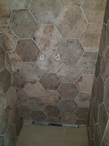 Flisearbejde med rustikke sekskantede fliser i bruseniche i Skive