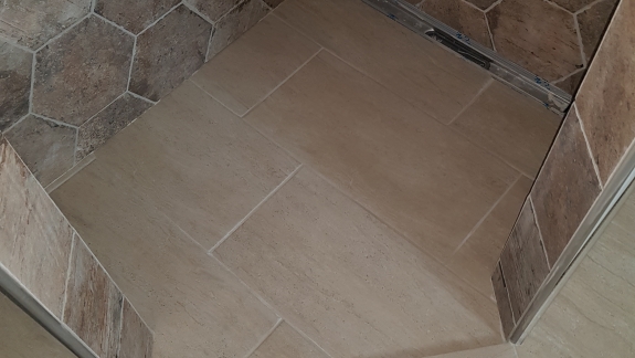 Flisearbejde på brusegulv med store klinker og afløb i Skive