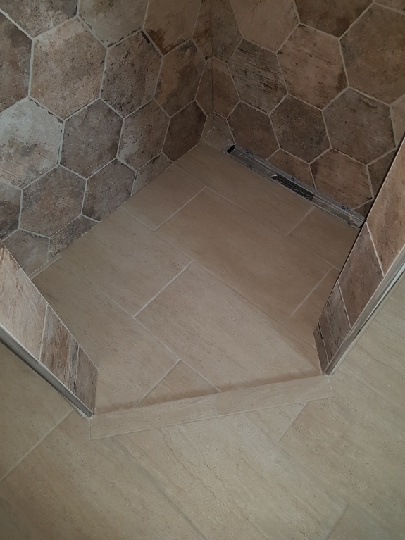 Flisearbejde på brusegulv med store klinker og afløb i Skive