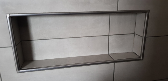 Flisearbejde med indbygget hylde i flisevæg på Salling